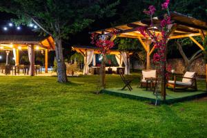 un cenador con sillas y una mesa en un parque por la noche en Green Oasis Gabella, en Castelforte