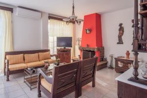 a living room with a couch and a fire place at FANI ROXANE APARTMENTS in Keratea