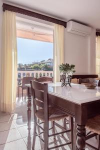 a dining room with a table and chairs and a window at FANI ROXANE APARTMENTS in Keratea