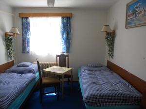 um quarto com duas camas e uma mesa e uma janela em Ubytování u Boženky em Destné v Orlických horách
