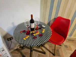 a table with a bottle of wine and wine glasses at Hotel la Pampa in Alto Hospicio