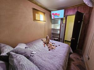 a stuffed dog laying on a bed in a bedroom at Hotel la Pampa in Alto Hospicio