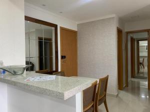 a kitchen with a counter with chairs and a table at Apartamento 2Q Próximo ao Albert Einstein EC1003 in Goiânia +16 photos