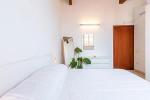 - une chambre avec un lit blanc et une porte en bois dans l'établissement Penthouse with Terrace in historic centre, à Cagliari