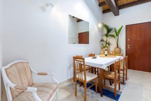 a dining room with a white table and chairs at Penthouse with Terrace in historic centre in Cagliari +15 photos
