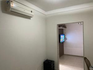 Cette chambre dispose d'un couloir avec une porte et d'une télévision. dans l'établissement Casa Verão Nova Almeida, à Nova Almeida