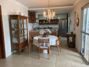 cocina con mesa y sillas y comedor en Casa Verão Nova Almeida, en Nova Almeida