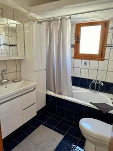 a bathroom with a tub and a toilet and a sink at Living Home Trikala in Tríkala +13 photos