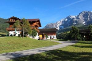 a house on a hill with mountains in the background at Reith-Gut in Mühlbach am Hochkönig