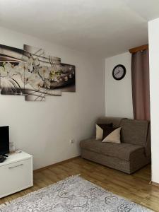 - un salon avec un canapé et un réveil sur le mur dans l'établissement Apartman Reyan, à Jajce