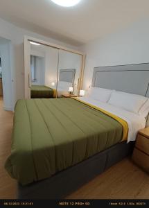 a large bed in a bedroom with a large mirror at Bonito Apartamento en Zamakola in Bilbao
