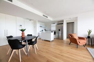 a kitchen and living room with a table and chairs at Sapphire of South Yarra - two bedroom condominium in Melbourne