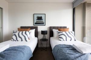 two beds sitting next to each other in a room at Sapphire of South Yarra - two bedroom condominium in Melbourne