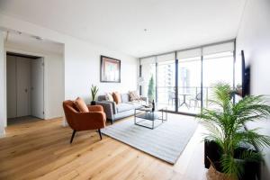 a living room with a couch and a chair at Sapphire of South Yarra - two bedroom condominium in Melbourne