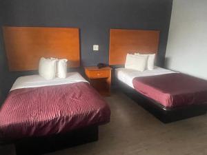 een hotelkamer met 2 bedden met rode lakens bij Americas Best Value Inn-Savannah in Savannah