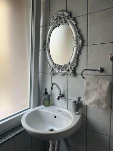 baño con lavabo y espejo en la pared en Apartman Reyan en Jajce