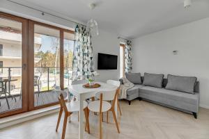 a living room with a couch and a table and chairs at STEGNA PARK C Apartamenty Piamola WiFi in Stegna