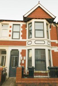 a red and white house with a black door at Cosmeston Cwtch by Property Promise in Cardiff