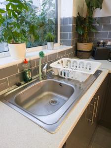 a kitchen sink with a dish drying rack on it at Cosmeston Cwtch by Property Promise in Cardiff