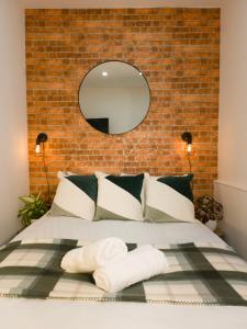 a bedroom with a bed with a brick wall at Cosmeston Cwtch by Property Promise in Cardiff