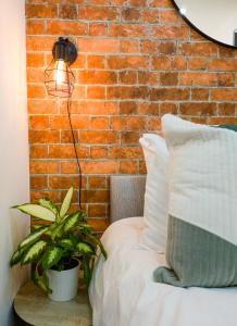 a bedroom with a brick wall and a bed with a lamp at Cosmeston Cwtch by Property Promise in Cardiff