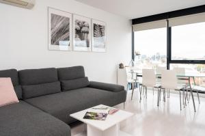 ein Wohnzimmer mit einem Sofa und einem Tisch in der Unterkunft UPTOWN City Views in the Heart of South Yarra in Melbourne