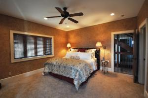 1 dormitorio con 1 cama y ventilador de techo en Buttercup Haven - Sweeping Mountain Views - 5 Star Rated Home - Hot Tub, en Franklin