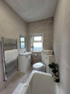 a bathroom with a tub and a toilet and a sink at Killawalla Cottage, Westport. in Westport +19 photos
