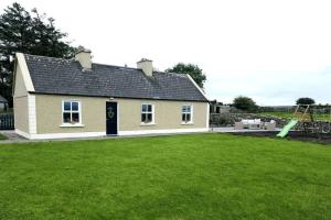 a house with a large yard in front of it at Killawalla Cottage, Westport. in Westport