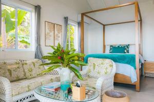 a living room with a couch and a table and a bed at Modern 1 bed guesthouse with pool and ocean view in Marigot