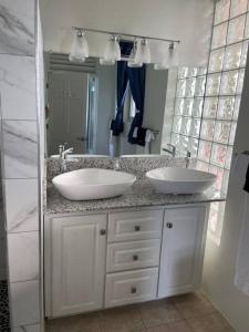 a bathroom with two sinks and a large mirror at Amazing mountain top home with stunning views in Marigot