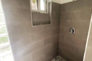 a bathroom with a shower with a window at Modern 1 bed guesthouse with pool and ocean view in Marigot