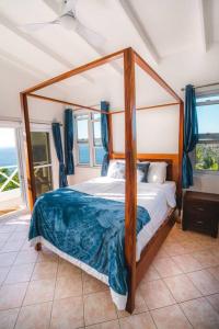 1 dormitorio con cama con dosel en una habitación en Amazing mountain top home with stunning views, en Marigot