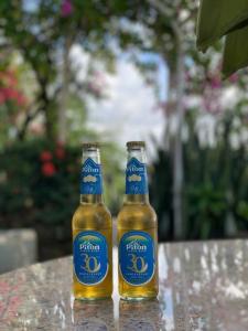 two bottles of beer sitting on top of a table at Modern 1 bed guesthouse with pool and ocean view in Marigot