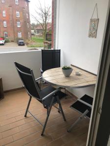a table and chair on a balcony with a view of a street at Wolkenlos in Butjadingen +22 photos