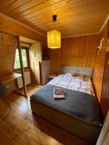 um quarto com uma cama num chalé de madeira em Agroturystyka Siedlisko em Lubowidz