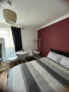 - une chambre avec un grand lit et un mur rouge dans l'établissement Large room with two bed in central london, à Londres