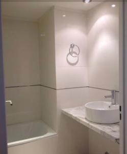 y baño blanco con lavabo y ducha. en Studio Libertador Premium! Location ! en Buenos Aires
