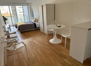 Habitación con cama, mesa y sillas. en Studio Libertador Premium! Location ! en Buenos Aires