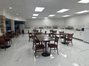 a dining room with tables and chairs and a kitchen at River Rapids Inn in Niagara Falls