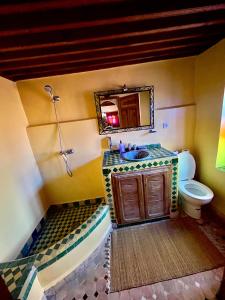 uma casa de banho com um lavatório, um WC e um espelho. em Dar Labchara em Fez