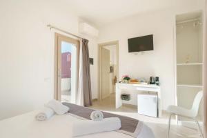 Habitación blanca con cama y espejo en TS ROOMS - Guest House Deidda en San Sperate