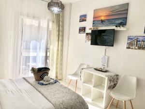 アテネにあるMon Apartment Edem beach Faliroのベッドルーム1室(ベッド1台、テーブル、椅子付)