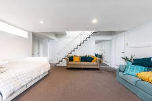 1 dormitorio con cama, sofá y escalera en Spacious 4BR House Close to DT, en Brossard