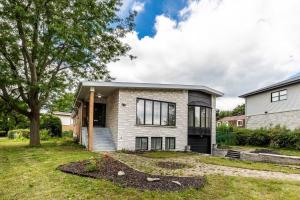 a brick house with a tree in the yard at Spacious 4BR House Close to DT in Brossard