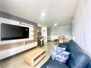 een woonkamer met een blauwe bank en een flatscreen-tv bij Torres de mayorca in Sabaneta