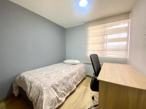 een slaapkamer met een bed, een bureau en een raam bij Torres de mayorca in Sabaneta