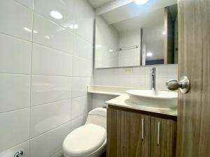 een badkamer met een wit toilet en een wastafel bij Torres de mayorca in Sabaneta