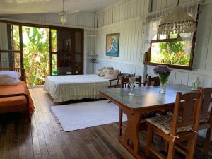 a bedroom with a bed and a table and chairs at Praia do Siriu in Siriú