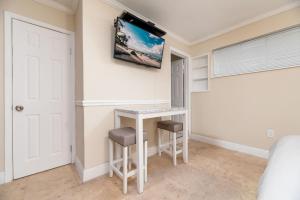 Ocean Breeze Free Parking Apt 2 في فورت لاودردال: غرفة نوم مع مكتب وتلفزيون على الحائط